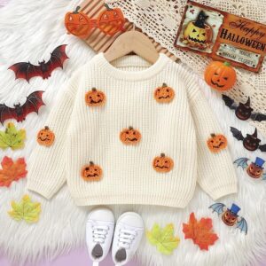 A cream jumper in a baby size is decorated with small halloween pumpkins