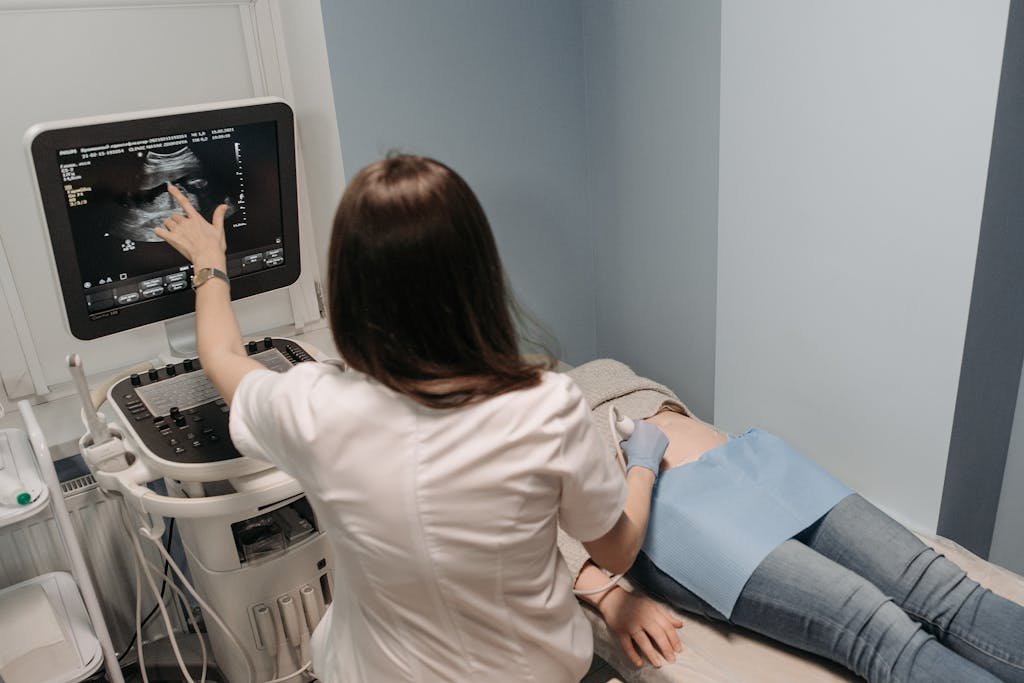 Female doctor conducting an ultrasound screening on a patient in a medical office.