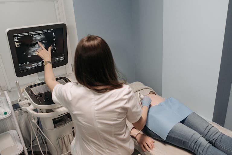 Female doctor conducting an ultrasound screening on a patient in a medical office whilst investigating cramping at 5 weeks pregnant