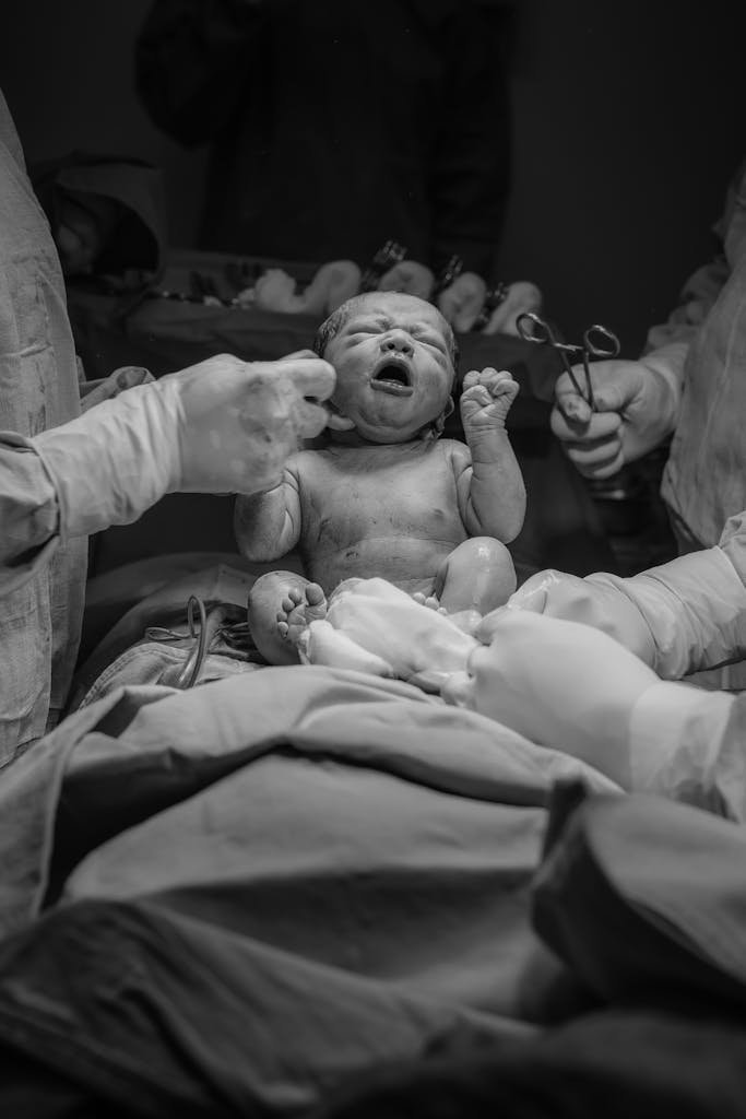 Captivating moment of a newborn's birth captured in black and white.
